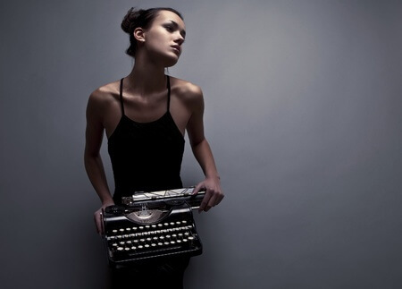 Woman holding a typewriter and avoiding  burnout